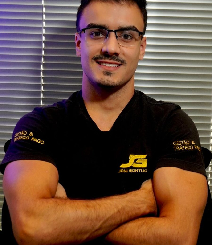 Denildo de braços cruzados, com a camiseta da JG Gestão e Tráfego Pago